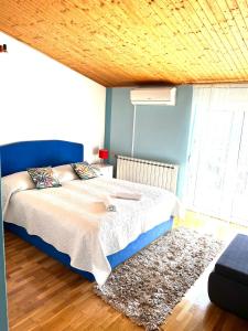 - une chambre avec un lit et un plafond en bois dans l'établissement Apartments Toni, à Podstrana