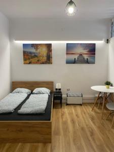 um quarto com uma cama e pinturas na parede em Cracow Old Town Rooms em Cracóvia