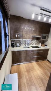 een keuken met roestvrijstalen kasten en een houten vloer bij 180 Home Luxury N. De Los Angeles in Sevilla