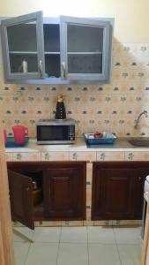 um balcão de cozinha com um micro-ondas e um lavatório em Al Rayane em Dakar