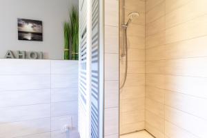 a shower in a bathroom with white walls at Reetdachhaus Ahoi Reetdachhaus Ahoi in Tating +31 photos