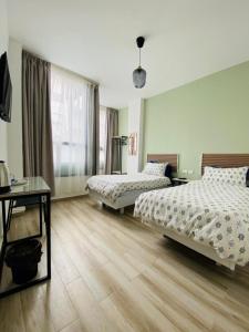 a bedroom with two beds and a table and a window at Arabesque Hotel in Amman