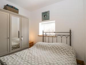 a bedroom with a bed and a cabinet and a window at Primose Cottage in Cromer