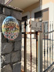 ein Schild an einer Wand neben einem Zaun in der Unterkunft Sweet House in Agerola