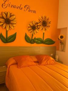 ナポリにあるB&B Flower's Houseの花の壁に飾られたオレンジ色のベッドルーム