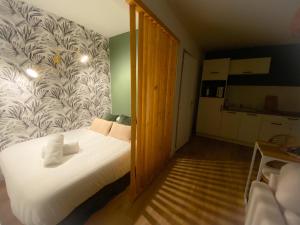 een kleine slaapkamer met een bed met witte lakens bij Le Studio Calaisien in Calais