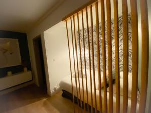 een slaapkamer met een bed en een houten leuning bij Le Studio Calaisien in Calais