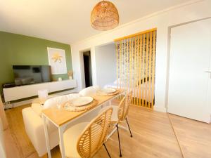 a dining room and living room with a table and chairs at Le Studio Calaisien in Calais