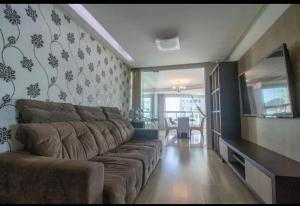 ein Wohnzimmer mit einem Sofa und einem Flachbild-TV in der Unterkunft APTO com linda vista para o Mar in Balneário Camboriú