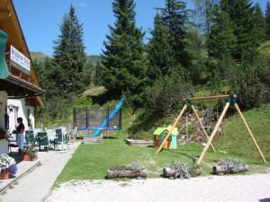 einen Hof mit einer Schaukel und einem Spielplatz in der Unterkunft Alpengasthof Grimmingblick in Planneralm