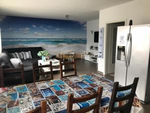 ein Wohnzimmer mit einem Tisch und einem Kühlschrank in der Unterkunft Ferienhaus Nahe der Ostsee in Bad Doberan