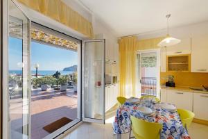 a kitchen and dining room with a table and a balcony at Attico Cielo e mare in Spotorno