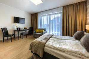 a hotel room with a bed and a desk and chair at Alibi Apartments in Wrocław