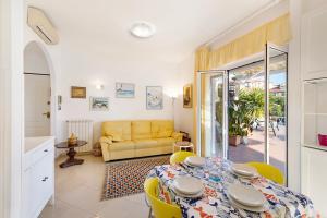 une salle à manger avec une table et un canapé jaune dans l'établissement Attico Cielo e mare, à Spotorno