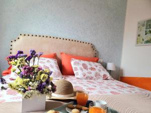 a bed with a table with a vase of flowers on it at Nelson Apartment in Limone sul Garda +48 photos