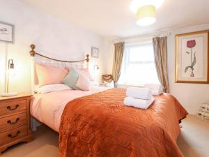 a bedroom with a large bed with towels on it at Meadow Cottage in Kendal