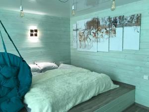 a bed in a room with white walls and pictures at Husky House in Kladkovka