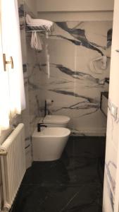 a bathroom with a white toilet and a black floor at Hotel Holiday- Alla Finestrella in Bologna