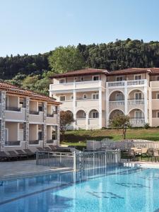 a hotel with a swimming pool in front of a building at Windmill Hotel in Argassi