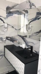 a bathroom with a black sink and a marble wall at Hotel Holiday- Alla Finestrella in Bologna