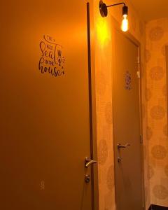 una puerta del baño con un cartel que dice el mejor asiento de la casa en Hotel Het Heilig Genot en Westvleteren