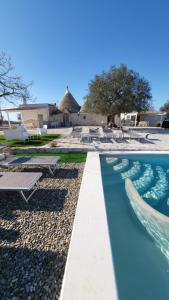 a pool at a resort with chairs and tables at Casa Relax Isabelle in Alberobello