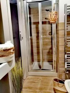 uma casa de banho com um chuveiro e uma porta de vidro em B&B DOMUS 65 em Aragona