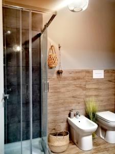 een badkamer met een douche, een toilet en een wastafel bij B&B DOMUS 65 in Aragona