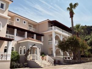 uma casa grande com uma palmeira em frente em Windmill Hotel em Argasi