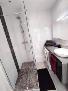 een badkamer met een douche, een wastafel en een wasmachine bij Classé 3 étoiles - Magnifique vue sur le port - Wifi et Clim in La Grande-Motte