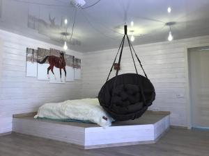 a room with a bed with a horse swing at Husky House in Kladkovka