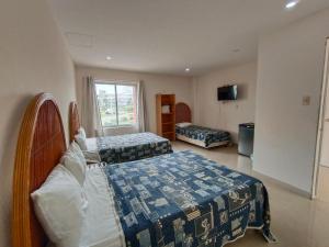 a hotel room with two beds and a television at Hotel Playa de Oro - Enfrente de WTC y Plazas Comerciales in Veracruz