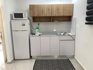 uma pequena cozinha com frigorífico e micro-ondas em Eilat-Inn Suites em Eilat