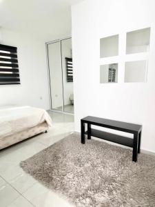 a bedroom with a bed and a black bench at Eilat-Inn Suites in Eilat