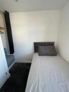 a small bedroom with a bed in the corner at VA Home Stay in Luton