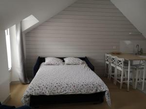Appartement Ty Cosy في كويبيرون: غرفة نوم بسرير وطاولة في غرفة