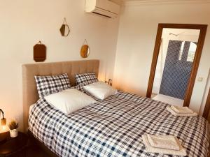 a bedroom with a bed with a checkered blanket at Denia Dream Seaview Golf, Tennis & Beach Villa in Muntanya la Sella