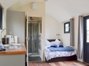 a bathroom with a bed and a sink in a room at Checkers Cottage - Beaufort Estate in Belladrum