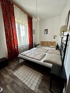 a bedroom with two beds and a large window at Kis Gellért Guesthouse in Budapest