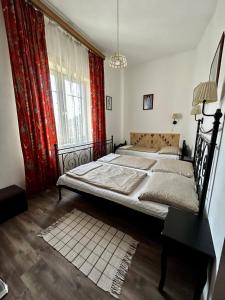 a bedroom with two beds and a large window at Kis Gell&eacute;rt Guesthouse in Budapest