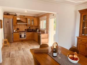 a kitchen with wooden cabinets and a table with a bowl of fruit at Denia Dream Seaview Golf, Tennis & Beach Villa in Muntanya la Sella