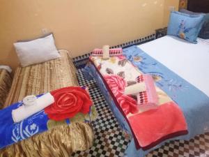 フェズにあるriad zahraのベッド2台が隣同士に設置された部屋です。