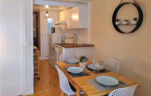 a dining room with a table and chairs and a kitchen at Beautiful Apartment In Grandcamp-Maisy in Grandcamp-Maisy +17 photos