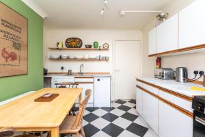a kitchen with a wooden table and green walls at Flat 2 Peter Lane Cosy 1-Bed Flat in the Heart of York City Centre Pass the Keys in York