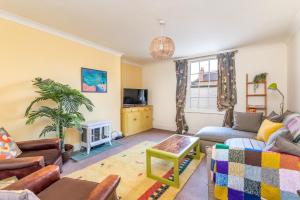 a living room with a couch and a tv at Newly Renovated City Centre Flat - Pass the Keys in York