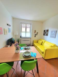 sala de estar con sofá amarillo y mesa en Nelson Apartment en Limone sul Garda