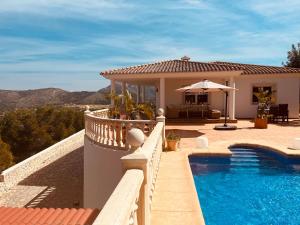 a villa with a swimming pool and a house at Denia Dream Seaview Golf, Tennis & Beach Villa in Muntanya la Sella