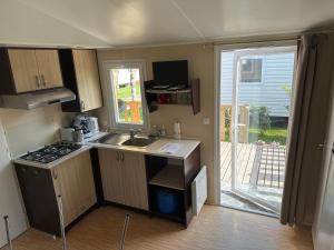 a small kitchen with a sink and a stove at Mobilhome 6 personnes in Saint-Georges-de-Didonne