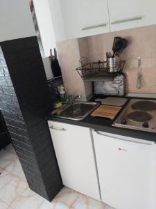 - une cuisine avec des placards blancs et un évier dans l'établissement Keti 2, à Belgrade