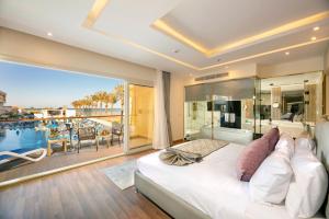 Bellagio Beach Resort & Spa في الغردقة: غرفة نوم بسرير كبير مطلة على مسبح